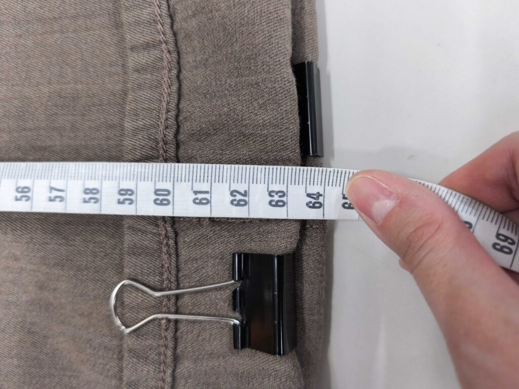 受付でスタッフが裾のクリップの位置と長さを確認する様子